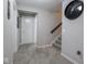 Hallway with grey walls and carpet features a set of stairs and a series of doorways at 5684 Autumn Trl, Brownsburg, IN 46112