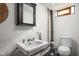 Compact bathroom with a pedestal sink, medicine cabinet, and toilet against textured walls at 6280 Washington Blvd, Indianapolis, IN 46220