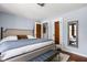 A cozy bedroom features light blue walls, hardwood floors, and a large comfortable bed with walk in closet at 6280 Washington Blvd, Indianapolis, IN 46220