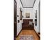 Charming entryway featuring a wooden bench, decorative mirror, and hardwood floors creating a warm welcome at 6280 Washington Blvd, Indianapolis, IN 46220