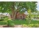 Charming brick home featuring lush green lawn and mature trees enhancing the curb appeal at 6280 Washington Blvd, Indianapolis, IN 46220