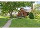 Charming brick home featuring lush green lawn and mature trees enhancing the curb appeal at 6280 Washington Blvd, Indianapolis, IN 46220
