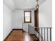 Bright hallway with hardwood floors and an iron railing leading to the upper level at 6280 Washington Blvd, Indianapolis, IN 46220