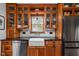 A kitchen with wooden cabinets, black countertops, and a white farmhouse sink beneath a window at 6280 Washington Blvd, Indianapolis, IN 46220