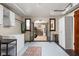 An open-concept laundry room with white cabinets, a freezer, and access to another room via iron gates at 6280 Washington Blvd, Indianapolis, IN 46220