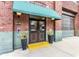 Building entrance with a brown double door, flowers and a green awning with the address above at 630 N College Ave # 409, Indianapolis, IN 46204