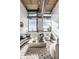 Inviting living room features exposed ductwork, large windows, a comfortable seating arrangement, and a stylish, neutral color palette at 630 N College Ave # 409, Indianapolis, IN 46204