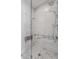 Modern shower with marble tile, glass enclosure, and built-in seating for comfort at 630 N College Ave # 409, Indianapolis, IN 46204