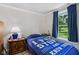 Cozy bedroom with blue bedspread and view of green backyard at 6691 N Baltimore Rd, Monrovia, IN 46157