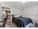 Bedroom with a dark bedspread and open door to kitchen at 6691 N Baltimore Rd, Monrovia, IN 46157