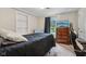 Cozy bedroom with a dark bedspread, wood dresser, and a window overlooking a green backyard at 6691 N Baltimore Rd, Monrovia, IN 46157