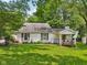 Charming home with a well-manicured lawn and a welcoming front porch, surrounded by mature trees at 6691 N Baltimore Rd, Monrovia, IN 46157