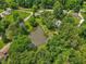 Aerial view of a pond surrounded by lush trees, green grass, and seating area at 6691 N Baltimore Rd, Monrovia, IN 46157