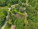 Aerial view of a pond surrounded by lush trees, green grass, and seating area at 6691 N Baltimore Rd, Monrovia, IN 46157