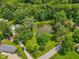 Aerial view of a pond surrounded by lush trees, green grass, and seating area at 6691 N Baltimore Rd, Monrovia, IN 46157