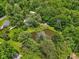 Aerial view of a pond surrounded by lush trees, green grass, and seating area at 6691 N Baltimore Rd, Monrovia, IN 46157