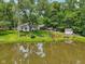 Scenic view of a pond near a cozy white home with a large green yard at 6691 N Baltimore Rd, Monrovia, IN 46157
