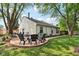 Backyard patio with a fire pit surrounded by Adirondack chairs and a well-maintained lawn at 6760 Navigate Way, Indianapolis, IN 46250