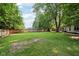 A spacious, fenced-in backyard with mature trees provides plenty of room for outdoor activities and relaxation at 6760 Navigate Way, Indianapolis, IN 46250