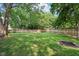 Large backyard with mature trees and well-maintained lawn, and fire pit at 6760 Navigate Way, Indianapolis, IN 46250