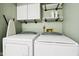 Well-equipped laundry area with a modern washer, dryer, white cabinets, and shelving at 6760 Navigate Way, Indianapolis, IN 46250