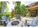 Multi-level backyard patio featuring fire pit, outdoor seating, and stairs leading to a covered area at 6940 Mockernut Ct, Plainfield, IN 46168