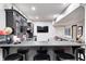 Basement wet bar with dark cabinetry, countertop seating, and decorative sports items at 6940 Mockernut Ct, Plainfield, IN 46168