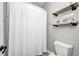 This bathroom has a white waffle pattern shower curtain and floating wood shelves at 6940 Mockernut Ct, Plainfield, IN 46168
