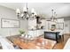 Open concept with a view into the dining area with a wood table and chair set, kitchen, and living room at 6940 Mockernut Ct, Plainfield, IN 46168