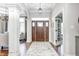 Grand foyer features wood door, large rug, chandelier, and views into adjacent living spaces at 6940 Mockernut Ct, Plainfield, IN 46168