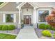 Charming front entrance with a decorative door, stone accents, and manicured landscaping at 6940 Mockernut Ct, Plainfield, IN 46168