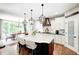 Modern kitchen features a large island with seating, white cabinets, and stainless steel appliances at 6940 Mockernut Ct, Plainfield, IN 46168