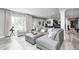Living room featuring a comfortable gray sectional, bright windows, and neutral decor at 6940 Mockernut Ct, Plainfield, IN 46168