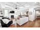 Open-concept living room with fireplace, built-in benches, hardwood floors, and view into kitchen at 6940 Mockernut Ct, Plainfield, IN 46168