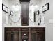 This bathroom features a dual sink vanity with dark wood cabinetry, white countertops and round mirrors at 6940 Mockernut Ct, Plainfield, IN 46168