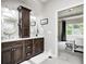 This bathroom features a dual sink vanity with dark wood cabinetry, white countertops, and modern faucets at 6940 Mockernut Ct, Plainfield, IN 46168
