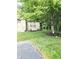 Landscaped yard with fresh green grass, mulch beds, and mature tree near house at 6956 Park Square Dr # D, Avon, IN 46123