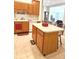 Kitchen featuring wood cabinets, white appliances, tile flooring, and a breakfast bar at 6956 Park Square Dr # D, Avon, IN 46123