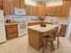 Kitchen features a breakfast bar, white appliances, wood cabinets, and a tile floor at 6956 Park Square Dr # D, Avon, IN 46123