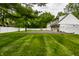 Spacious backyard includes a basketball court area, lush lawn, and a white privacy fence at 7105 Sylvan Ridge Rd, Indianapolis, IN 46240