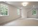 Spacious bedroom featuring neutral carpet, three windows, and modern lighting at 7105 Sylvan Ridge Rd, Indianapolis, IN 46240