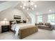 Bedroom showcasing an elegant bed, nightstand, and sitting area complemented by natural light from multiple windows at 7105 Sylvan Ridge Rd, Indianapolis, IN 46240