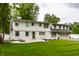 Beautifully landscaped yard with fire pit and a two-story home with a gray painted garage at 7105 Sylvan Ridge Rd, Indianapolis, IN 46240