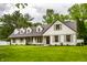 Beautiful exterior of a white home with a well-manicured lawn and a walkway, surrounded by mature trees at 7105 Sylvan Ridge Rd, Indianapolis, IN 46240