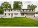 Well-manicured lawn, two-story home with a gray painted garage, and a white fence at 7105 Sylvan Ridge Rd, Indianapolis, IN 46240