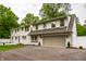 Inviting two-story home with a gray painted garage, mature landscaping, and a white fence at 7105 Sylvan Ridge Rd, Indianapolis, IN 46240