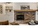 Rustic brick fireplace featuring a wooden mantel and built-in shelves for decor and storage at 7105 Sylvan Ridge Rd, Indianapolis, IN 46240