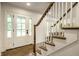 Inviting foyer featuring a staircase with wood and white railings, and a bright, welcoming entrance at 7105 Sylvan Ridge Rd, Indianapolis, IN 46240