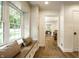 Bright hallway with wood floors, a built-in bench, and a view of the living room and kitchen at 7105 Sylvan Ridge Rd, Indianapolis, IN 46240