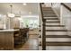Open concept kitchen flowing into staircase with island seating, white cabinets, and natural light at 7105 Sylvan Ridge Rd, Indianapolis, IN 46240